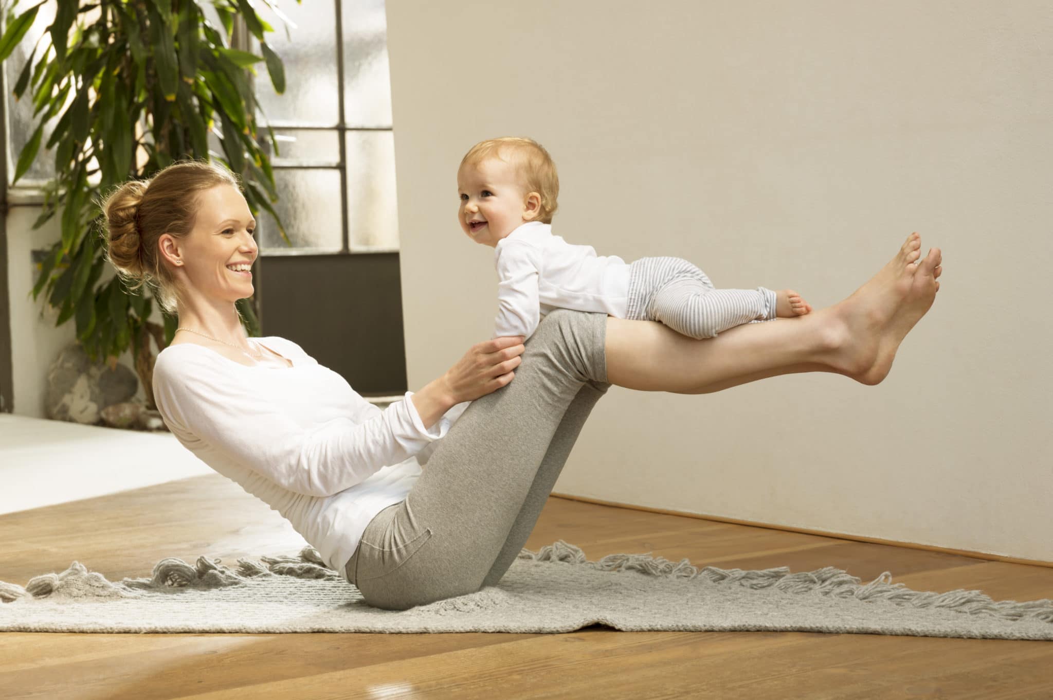 Woman balancing baby on her legs